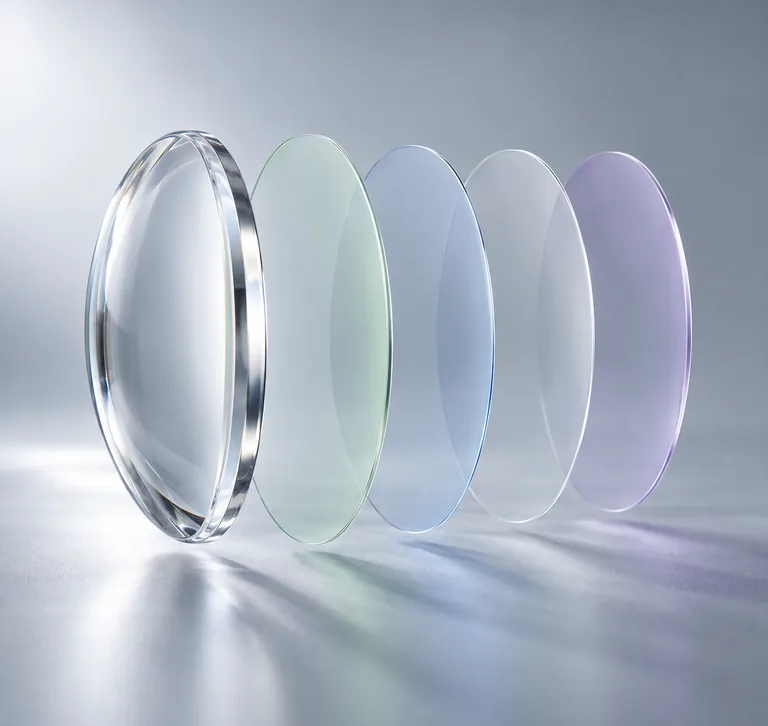 Lente transparente con sus capas de tratamiento separadas en fila, sobre fondo gris claro.